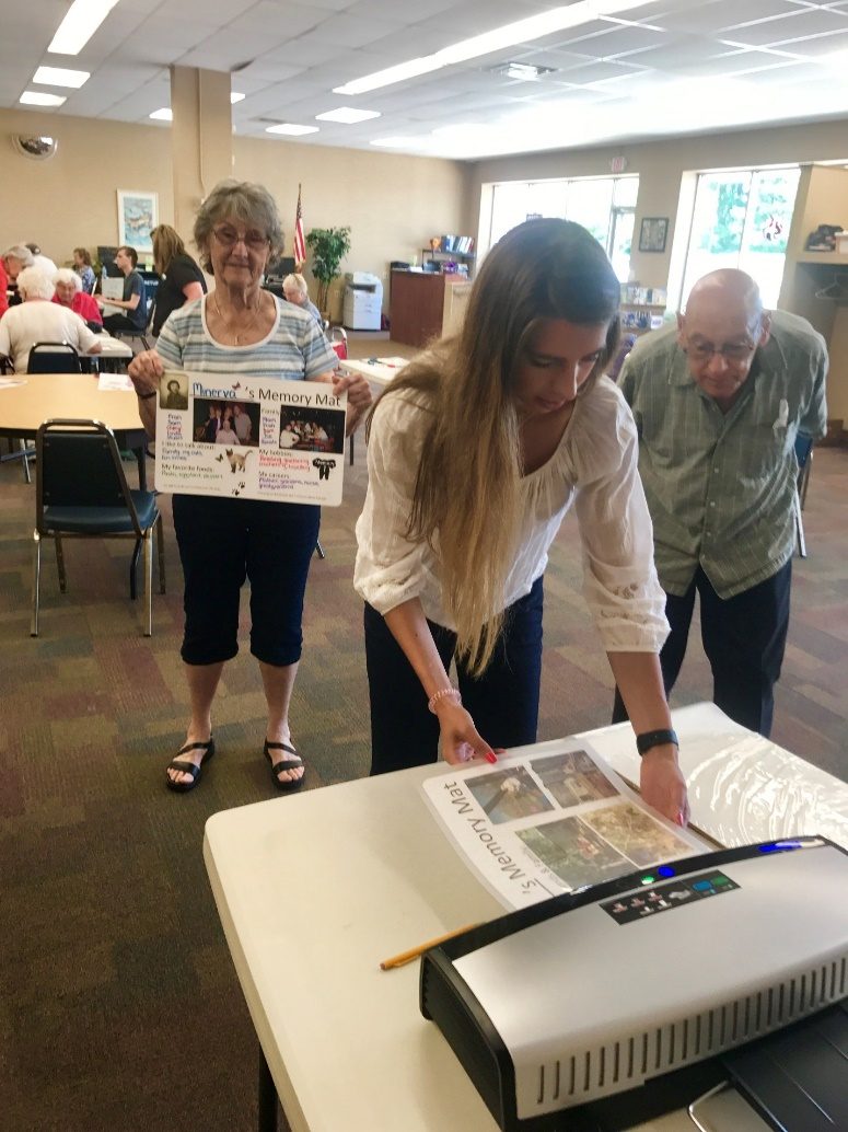 A volunteer helping a senior build a Memory Mat