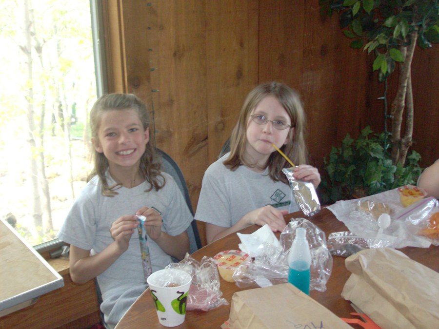 Two young volunteers making crafts together at a senior center visit